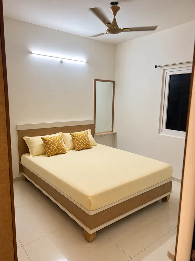 Bedroom with wood-finish headboard and dresser, completed by Casa Interiors in Hyderabad