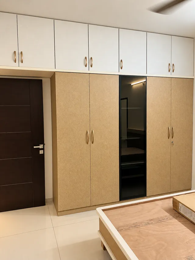 Wardrobe in textured beige laminate with lofts, completed by Casa Interiors in Hyderabad